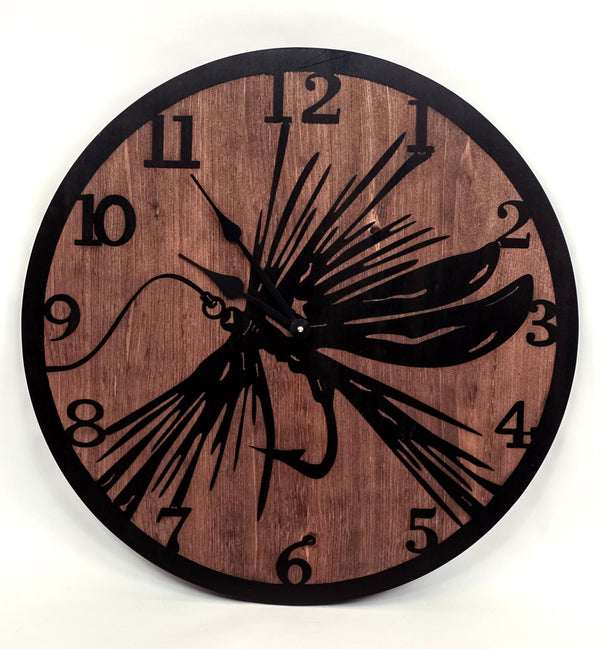 Our Fly Fishing Lure Etched Wood and Metal Rustic Round Wall Clock  is 24” in diameter and has been handcrafted in the USA. This custom made to order wood wall clock will transform any wall in your home and/or your rustic lodge cabin.  The solid wood is cut and etched with a large fly lure which has been stained black to contract the natural stained wood background, then finished with simple black metal hands for telling the time and to add extra stylish decorative touches.