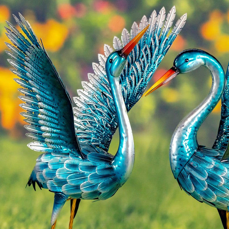 Our Metallic Blue Green Coastal Crane Garden Statuary comes as a set of 2. These metal crane garden birds are crafted from high quality metal, powder coated for added protection against weatherization, and individually hand painted for a unique one-of-a-kind outdoor decoration. Whether you add these cranes to your coastal home or rustic home, they will enhance any front lawn, backyard, or bird garden with their magnificent turquoise finish and stunningly detailed bodies and feathers.