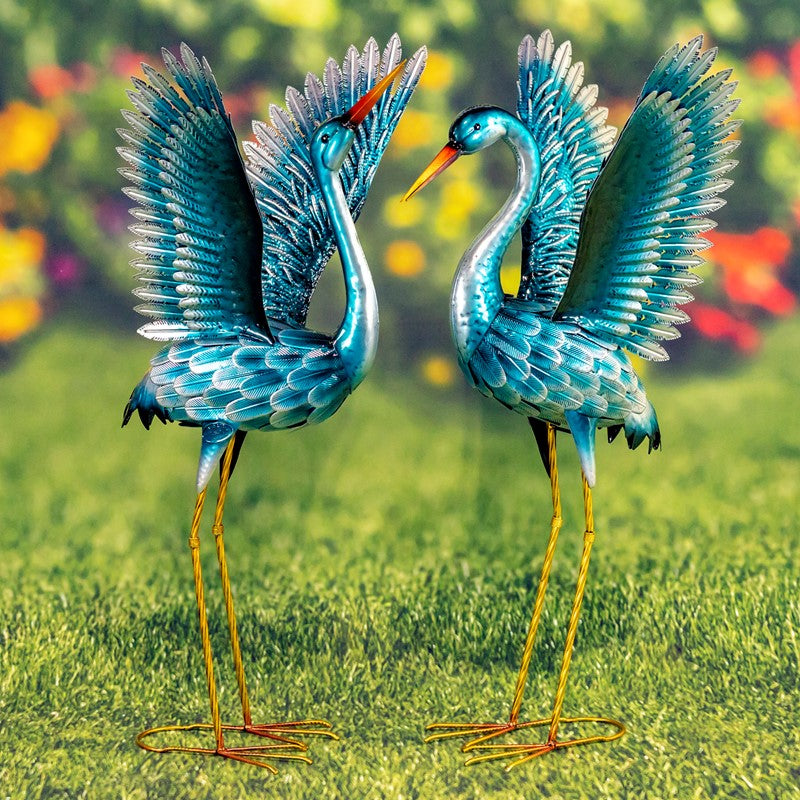 Our Metallic Blue Green Coastal Crane Garden Statuary comes as a set of 2. These metal crane garden birds are crafted from high quality metal, powder coated for added protection against weatherization, and individually hand painted for a unique one-of-a-kind outdoor decoration. Whether you add these cranes to your coastal home or rustic home, they will enhance any front lawn, backyard, or bird garden with their magnificent turquoise finish and stunningly detailed bodies and feathers.