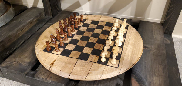 Our Reclaimed and Repurposed Bourbon Barrelhead Chess Set has been handcrafted by skilled artisans here in the USA and they have added beauty, detail and rustic charm to this set. The board has been laser engraved with the outline of the chess board and comes with a full set of chess pieces. The natural finish of the barrelhead board has been sealed with a clear coat finish to keep it beautiful for years of use. Size is 21” in diameter x 1.5” in depth and weighs 14 pounds. 