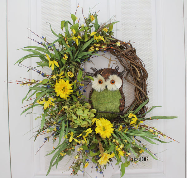 Our 24” in diameter twig based wreath features one twig exposed side with an adorable owl sitting front and center to welcome guests to your home. Our wise owl is surrounded by faux yellow flowers, with lots of greenery and an abundance of wispiness’ and ready to impress guests who come to your front door.   This wreath is handcrafted here in the USA and will be custom made for you by our skilled artisans who have an eye for detail.
