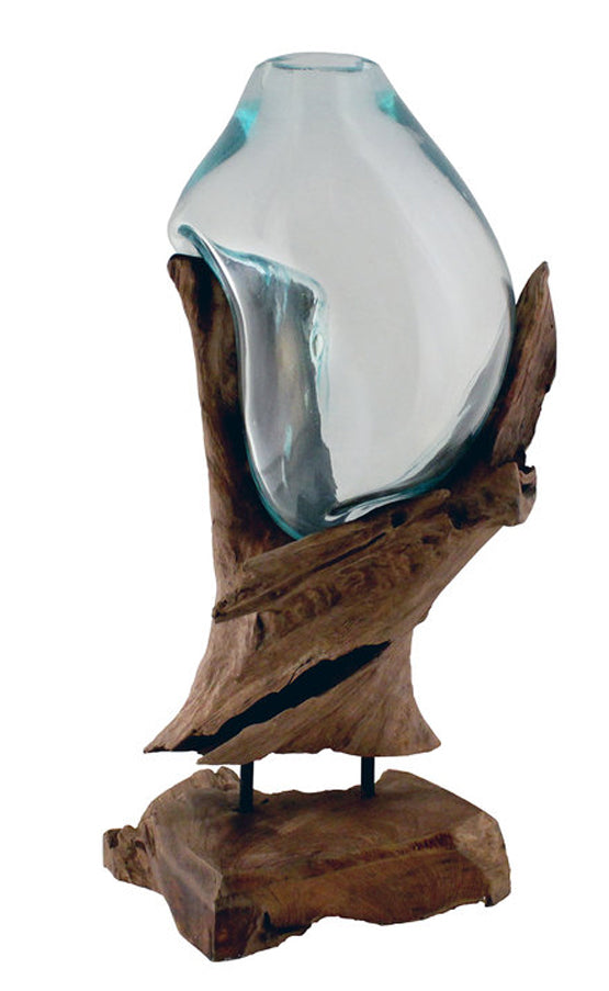 This 12” tall handblown glass and teak wood sculpture has been handcrafted by skilled artisans who have a love for the art of glass blowing. Recycled glass is blown onto the shape of the teak wood root and begins to flow and cradling the form of the wood to create a bowl that is a unique, one of a kind, piece that can be used as a vase, terrarium or fishbowl.