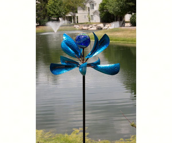 Add fun, function and curb appeal to your garden with our Blue Glow in the Dark Counter-Motion Wind Spinner. The blue metal counter motion paddles will catch the wind on a windy day and rotate in opposite directions via perpetual motion. In the center of the paddles sits a beautiful blue handblown glass globe which has luminescent crystals inside the ball, allowing it to store light energy during the day and release it at night in the form of a subtle green glow. 