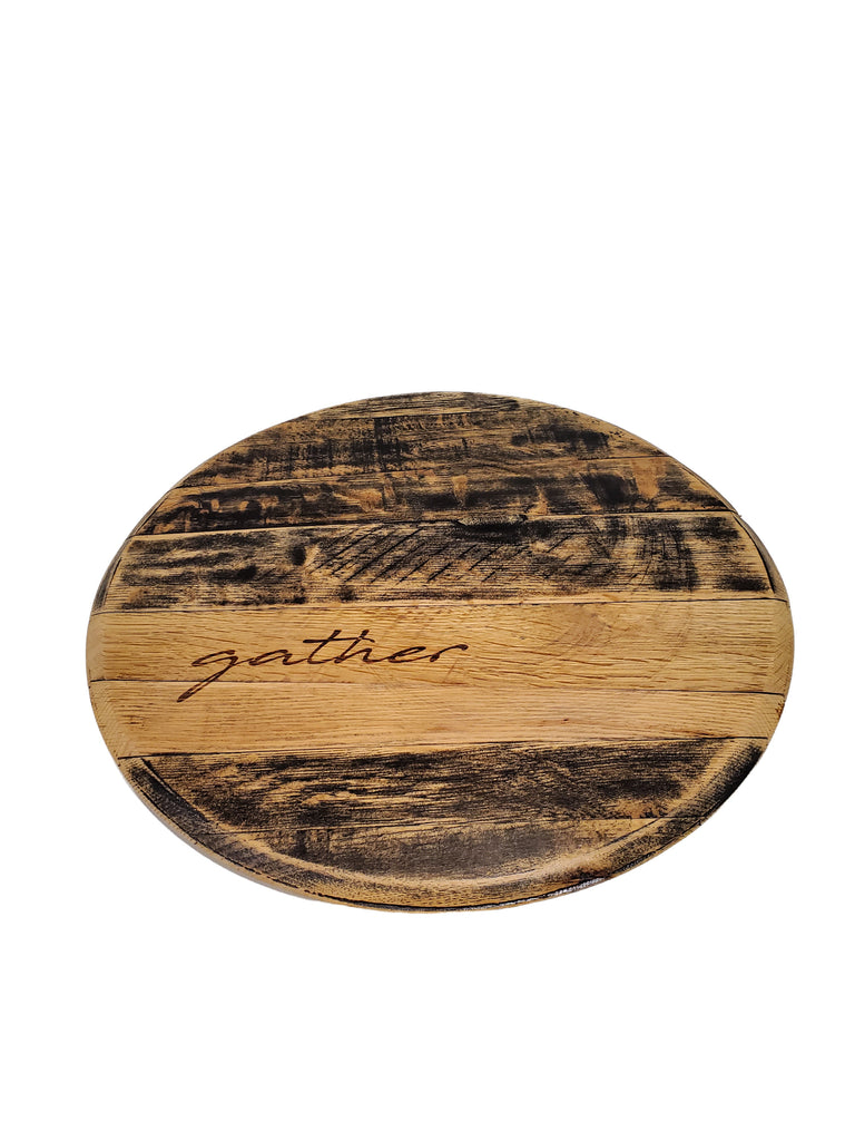 Shown, our distressed black Bourbon Barrel Head Lazy Susan without handles, engraved with one of our script choices of gather. Each piece is custom made to order, 21” in diameter and are customizable with or without handles in you’re your choice of script option text of blessed - bon appetit - charcuterie - do small things with great love - gather - grateful - thankful - this is us, or, get extra creative and create your own script option.