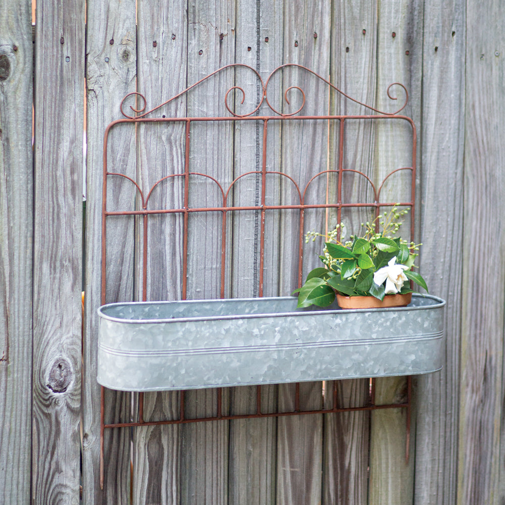 Our Metal Garden Fence Planter is made of wrought iron with an inground stake and resembles a garden fence. The planter bucket is made of galvanized steel and the contrasting color of the rust and silver is so pretty. This versatile planter can be used inground or hung on a wall or fence for a whole new look. Picture shows the planter hung on a wall.