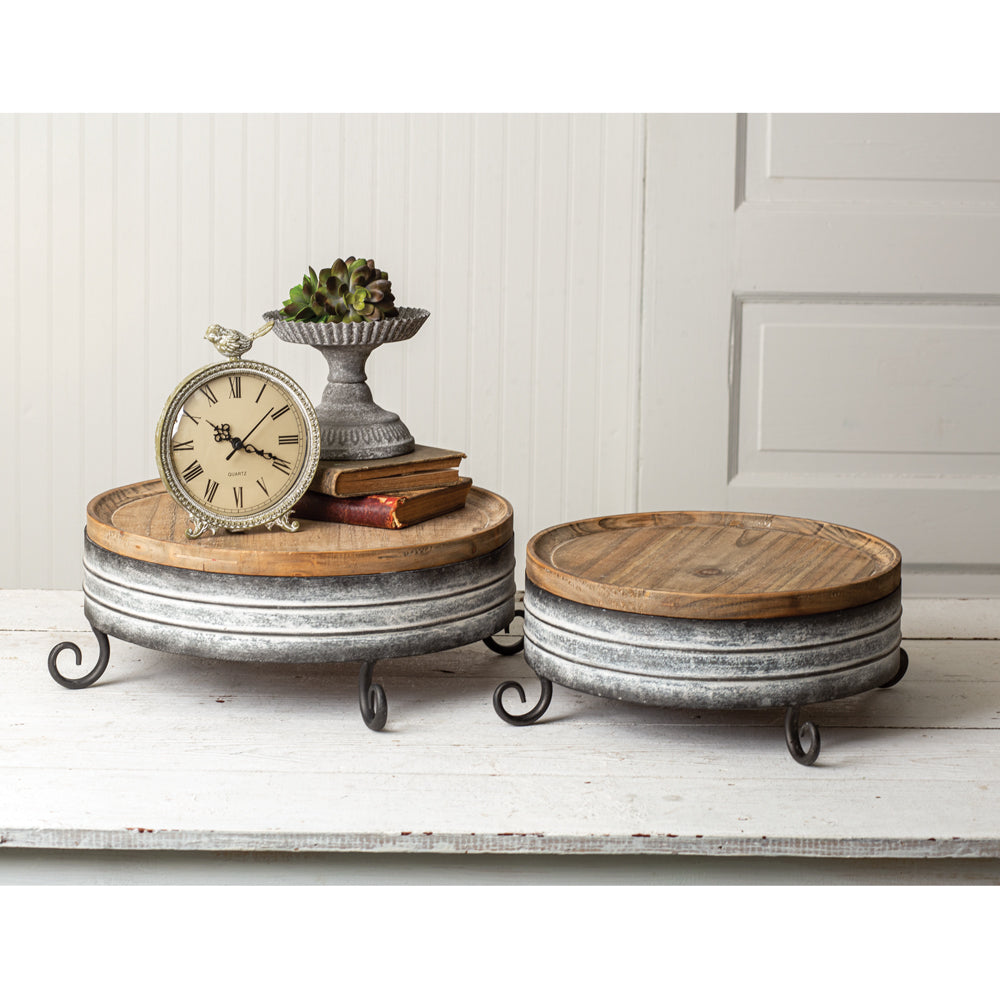 Our Metal and Wood Display Riser Stands, Set of 2 can be used for so many functions. With their country rustic metal flair they can be used together or separately to display food or other items. Sizes are: Large: 17'' in diameter x 6'' tall. Small: 15'' in diameter x 5'' tall.