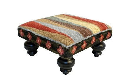 Our Pinwheel of Stripes Handcrafted Hooked Wool Footstool features vibrant colors and is 16” square x 8” tall and a great accent piece to use to put your feet up after a long hard day