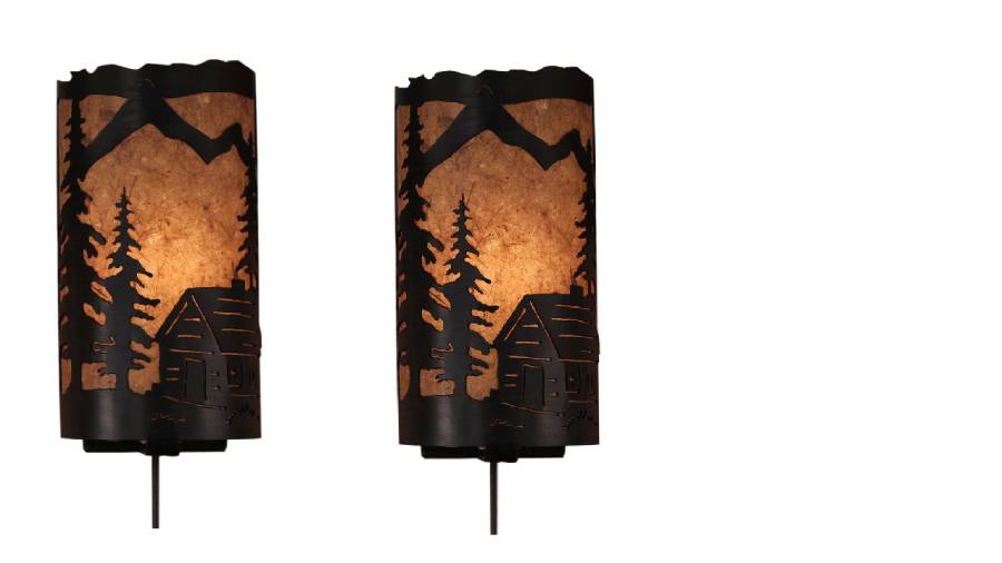 Our Rustic Cabin Panel Wall Sconces (set of 2) captures the forested beauty with cutouts of a metal cabin and trees in front of the amber parchment paper shade
