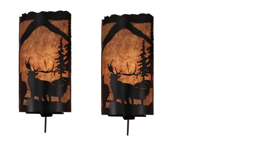 Our Rustic Elk Panel Wall Sconce (set of 2) captures the forested beauty with cutouts of metal elk and trees in front of the amber parchment paper shade
