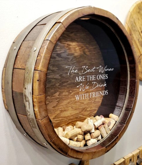  Shown in our walnut stain, this wall mountable Wine Barrel Head Cork Holder has been etched with The Best Wines Are The Ones We Drink With Friends. It is 21” in diameter x 7” deep and handcrafted, here in the USA, from the use of reclaimed and repurposed wine barrels, wine staves, barrel bands, and clear Plexiglas front, enabling you to view your collection of corks.  You can personalize the front of the Plexiglas with this memorable quote or a memorable quote of your choice.
