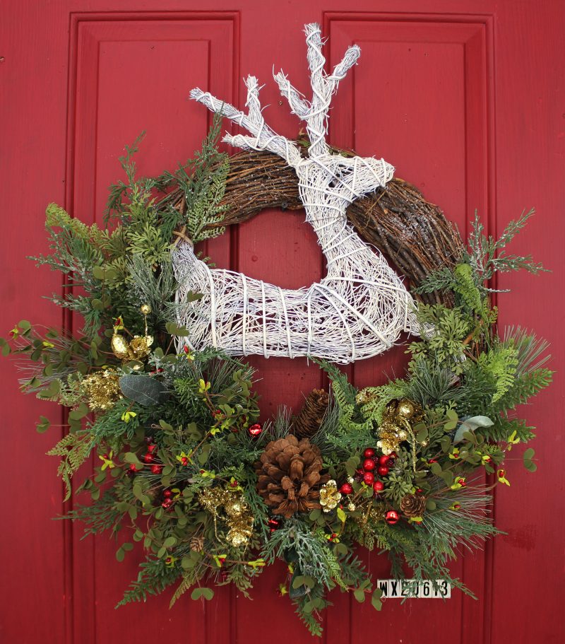 Our White Deer Christmas Winter Front Door Wreath is handcrafted here in the USA and features fa top exposed grapevine wreath that that has been wrapped with an assortment of eye catching wispy greenery, pinecones, gold embellishments and red berries. This 24” in diameter wreath is ready to be proudly hung on your front door décor to capture curb appeal at its finest with lots of color, creativity and style for Christmas and the winter season as well.