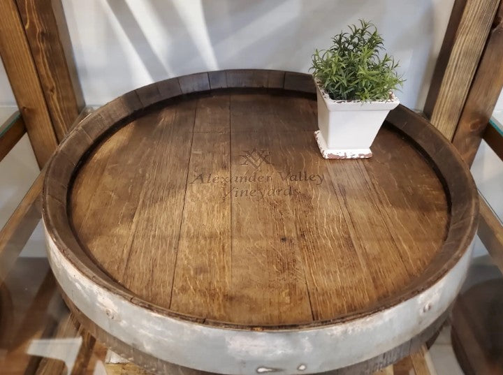 Shown is our 24” in diameter Wine Barrel Head Lazy Susan With Ring and Original Barrel Stamps, finished our walnut stain. Each unique piece is handcrafted here in the USA from reclaimed and repurposed authentic wood wine barrel heads. The lazy susan features the original wine barrel with ring as well as the winemakers original barrel stamps/markings that were added when the wine was being stored and fermented. 