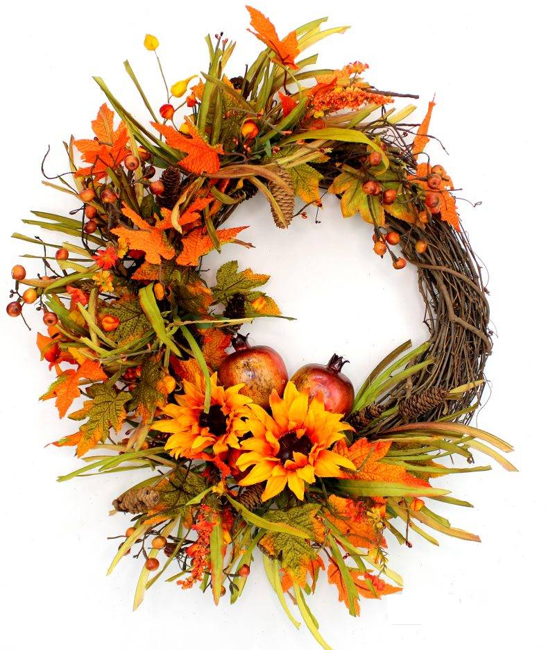 Handcrafted here in the USA, our Wispy Sunflower and Pomegranates Fall Grapevine Front Door Wreath is 24 inches in diameter and features a stunning array of fall colors. features a side exposed grapevine wreath that has been wrapped with an assortment of eye catching orange leaves, wispy greenery, berries and two bright sunflowers embracing pomegranates.