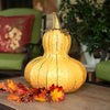 Our Yellow Gourd Indoor/Outdoor Candle Luminary Lantern is handcrafted from all weather steel gourd will certainly make a statement indoors or outdoors. The bottom of the gourd is open to add a flameless candle, 3-wick jar candle or battery puck light of your choice. The pretty yellow color looks great by itself or added to one of our pumpkin luminary lanterns. Size is 12”W x 15.5”H.
